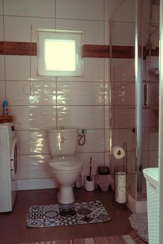 a bathroom with a toilet and a small window at Romantyczny Domek in Kalej