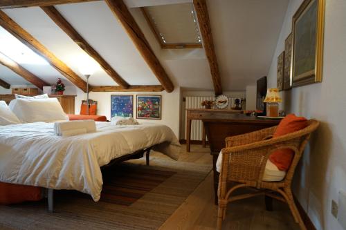 a bedroom with a large bed and a desk at Appartamento Les Cimes in Bardonecchia