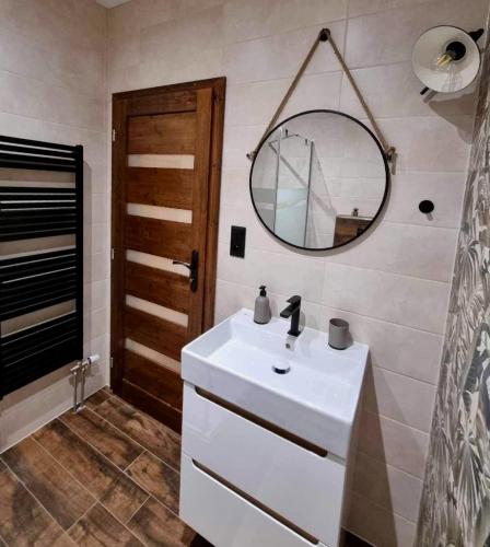 a bathroom with a white sink and a mirror at HARMONY Apartments in Rajecké Teplice