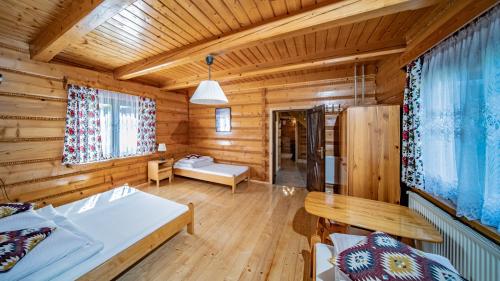 Dormitorio en cabaña de madera con cama y mesa en Domek Góralski en Piwniczna