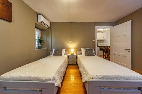 - 2 lits dans une chambre avec une cuisine dans l'établissement Trinity Apartment, à Anemómylos