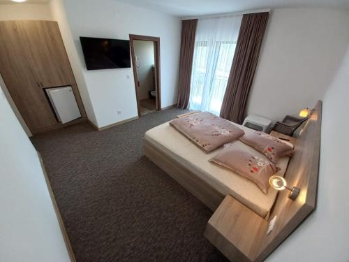 a bedroom with a large bed with pink pillows at king in Baile Felix