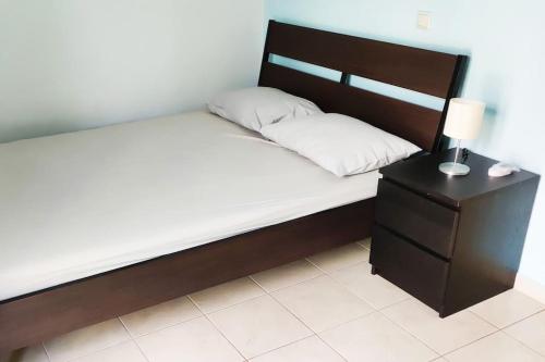 1 cama con cabecero de madera y mesita de noche en Sissy Villas 2, en Poros