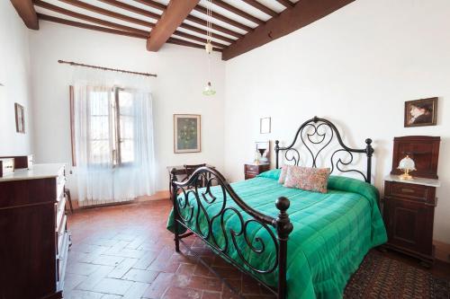 ein Schlafzimmer mit einem grünen Bett in einem Zimmer in der Unterkunft Residenza D'Epoca Palazzo Buonaccorsi in San Gimignano