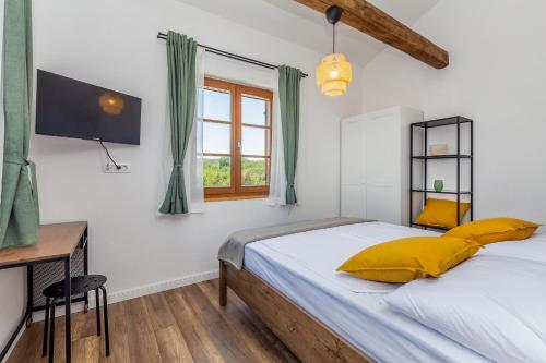 una camera da letto con letto con cuscini gialli e scrivania di Kuća za odmor ADRIATIC DREAM a Sveti Ivan