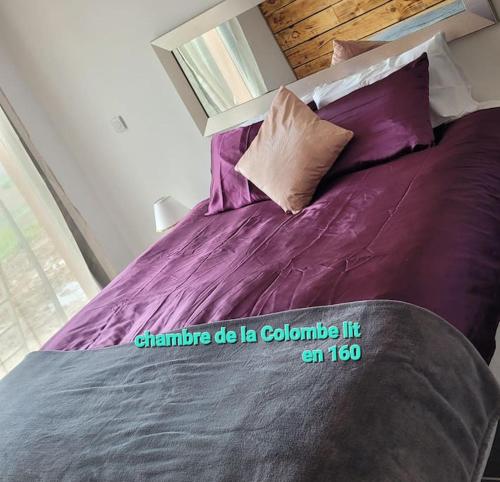 - un lit avec des draps et des oreillers violets dans une chambre dans l'établissement NiD'Amour Gîte La Colombe, à Bézenac