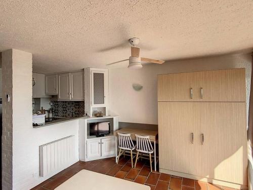 - une cuisine avec une table, des chaises et un comptoir dans l'établissement Studio en bord de mer, rez de jardin, accès plage - FR-1-610-90, à Bormes-les-Mimosas
