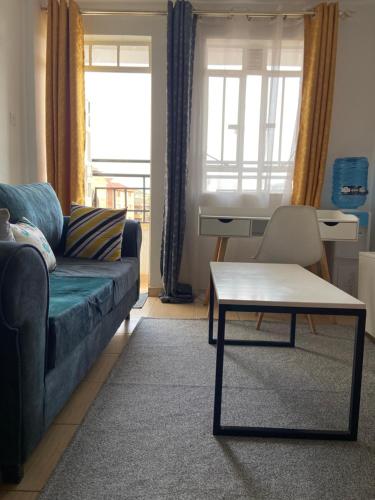 Comfy One Bedroom Apartment at Joyland Ruaka في Ruaka: غرفة معيشة مع أريكة وطاولة قهوة