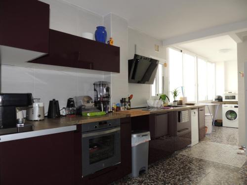 a kitchen with brown cabinets and a stove top oven at Chambre en colocation in Gandía