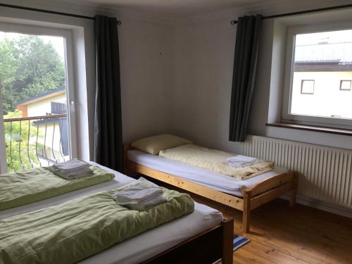 two twin beds in a room with a window at Haus Schmid Mattsee in Mattsee