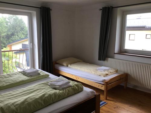2 Einzelbetten in einem Zimmer mit Fenster in der Unterkunft Haus Schmid Mattsee in Mattsee