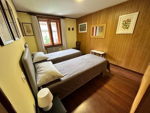 a hotel room with two beds and a window at Appartamento Centro Breuil CIR 0139-0142 in Breuil-Cervinia