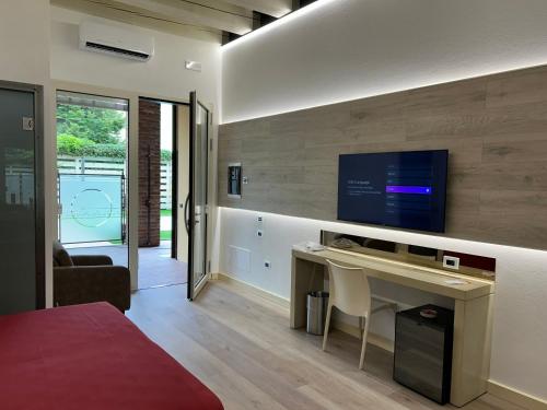 a bedroom with a desk and a tv on a wall at Luna Residence Hotel in Casalmaggiore