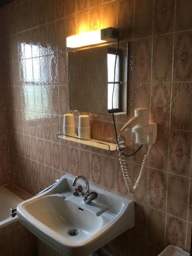 W łazience znajduje się umywalka i lustro. w obiekcie Haus Schmid Mattsee w mieście Mattsee