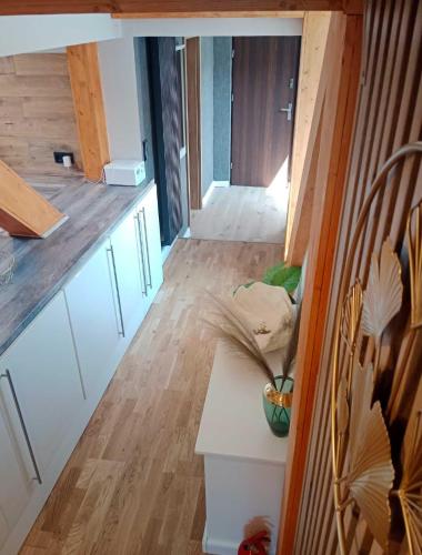 a kitchen with white cabinets and a wooden floor at FeWoNeustadt-02 in Neustadt in Holstein