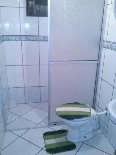 a bathroom with a green and white toilet and a sink at Pousada Margareth in Ilha do Mel