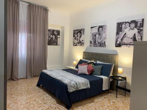 um quarto com uma cama azul com cartazes na parede em Civico 85 em Roma