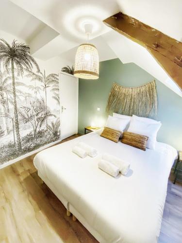 a bedroom with a white bed with a palm mural at La casa Terracotta - centre ville , spacieux & confortable in Béthune