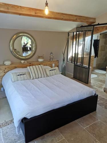 une chambre avec un grand lit avec un miroir dans l'établissement Villa proche d’Avignon, à Rochefort-du-Gard