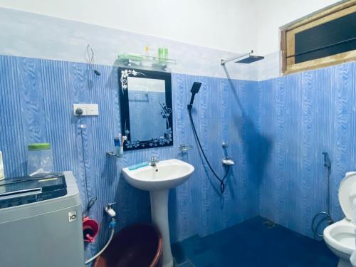 uma casa de banho azul com um lavatório e um chuveiro em SAKURA Guest House Tourist only em Wariyapola