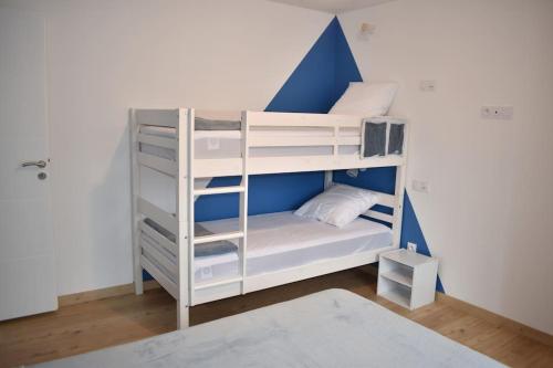 a bunk bed with white bunk beds in a room at Maison climatisée accessible PMR in Argelès-Gazost