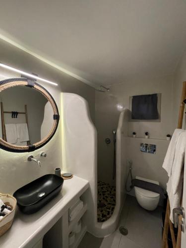 a bathroom with a sink and a toilet and a mirror at Egea House in Stelida