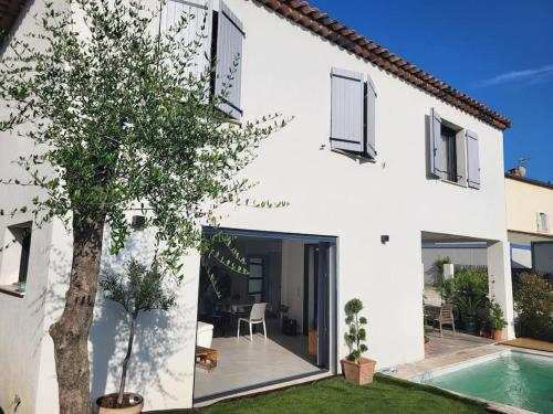 une maison blanche avec une piscine dans la cour dans l'établissement Maison avec piscine Côte d'Azur, à Auribeau-sur-Siagne