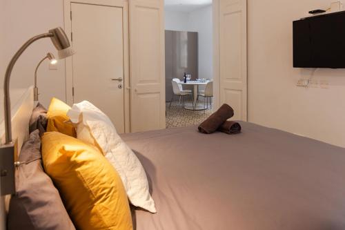 Un dormitorio con una cama con almohadas amarillas y blancas. en Casa Nico, en San Julián