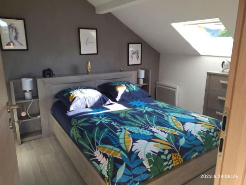 - une chambre avec un lit et une couette colorée dans l'établissement La chèvrerie, à Taintrux