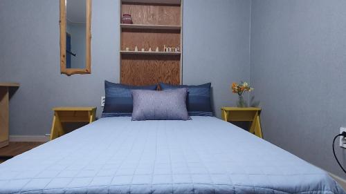 a bedroom with a blue bed with blue pillows at Yachtie Inn Yudal in Mokpo