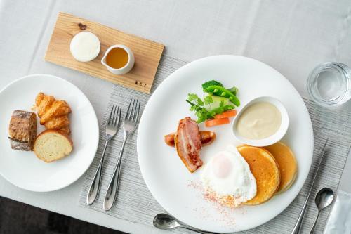 a white plate of food with eggs and other foods at Hotel Arc Riche Toyohashi in Toyohashi