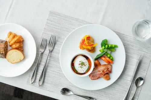 a white plate with food on a table with silverware at Hotel Arc Riche Toyohashi in Toyohashi