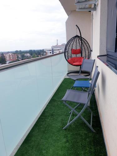 a pair of chairs and a swing on a balcony at Global Residence Lake View in Bucharest