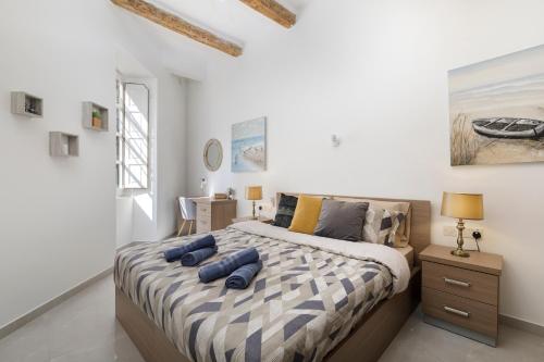a bedroom with a bed with blue pillows on it at Modern, Cosy 1BD Apartment - Close to Valletta in Hamrun