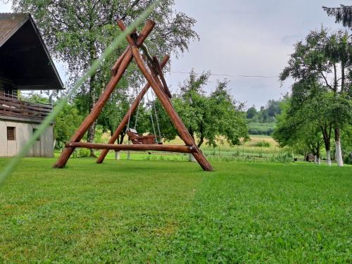 a wooden swing in a field of grass at Rest House Korana in Karlovac