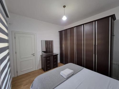 a bedroom with a bed and a wooden cabinet at Zyli Apts, BY Bunker Art 2 Museum, Tirana in Tirana