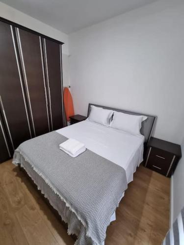 a bedroom with a large bed with white sheets at Zyli Apts, BY Bunker Art 2 Museum, Tirana in Tirana