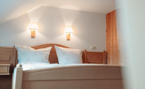 a bedroom with a bed with two lights on the wall at SONNE Wilhams in Missen-Wilhams