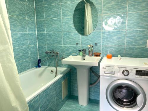 łazienka z pralką, umywalką i pralką w obiekcie Guest house Ayperi w mieście Bokonbayevo