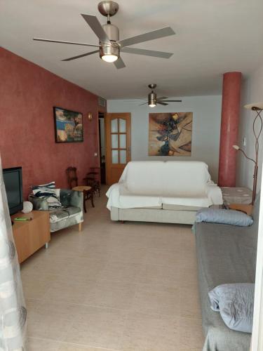 uma sala de estar com uma cama e uma ventoinha de tecto em Estupendo piso en L'AMPOLLA em L'Ampolla