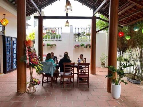 a group of people sitting at a table in a restaurant at Cua Dai Beach Homestay in Hoi An