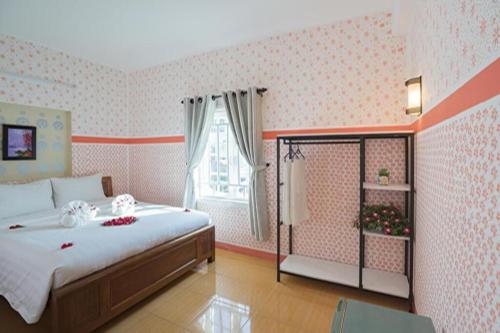 - une chambre avec un grand lit et une fenêtre dans l'établissement Cua Dai Beach Homestay, à Hội An