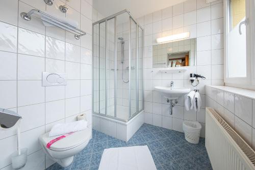 bagno bianco con servizi igienici e lavandino di Gästehaus Rudolfo a Zell am See
