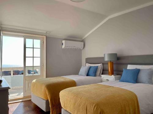 een slaapkamer met 2 bedden en een raam met uitzicht bij Sun's House in Ericeira