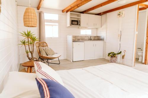 a room with a bed and a kitchen at Dreamsea Bungalows Alentejo in Porto Covo