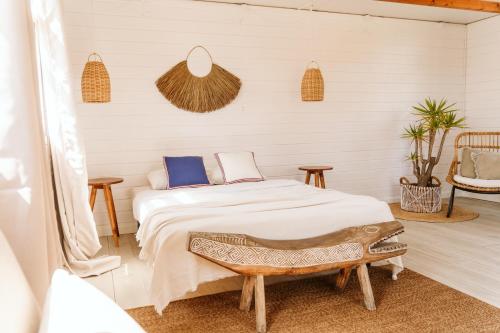 a bedroom with a bed and two tables at Dreamsea Bungalows Alentejo in Porto Covo