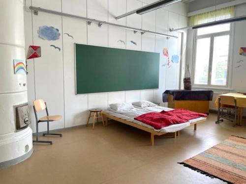 um quarto com uma cama e um ecrã na parede em Retkeilymaja Virkkula em Kuopio