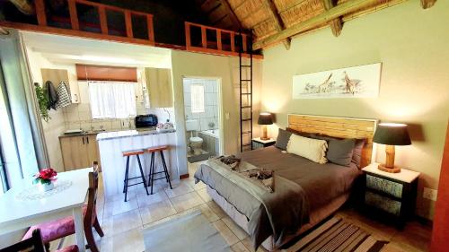 a bedroom with a bed and a kitchen with a counter at Wild Forest Inn in Graskop