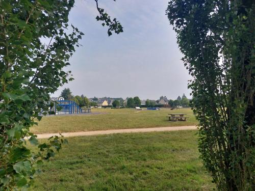 a park with a picnic bench and a playground at Appartement plein centre in Broons