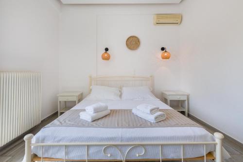 a bedroom with a white bed with towels on it at Christiana Hotel in Ambelas